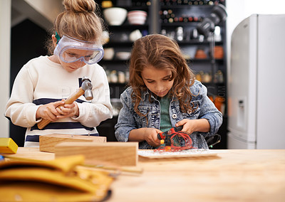Buy stock photo Children, construction and building in workshop with tools, play and game in kitchen of home. Girls, hammer and safety glasses for wood project on weekend, carpentry and woodworking or manufacture