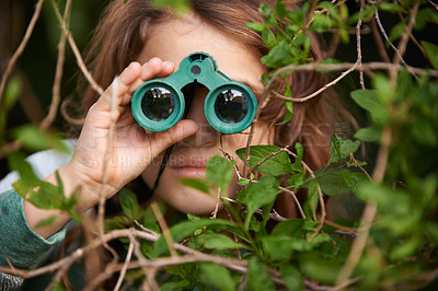 Buy stock photo Shot of a cute little girl looking through a pair of binoculars outdoors