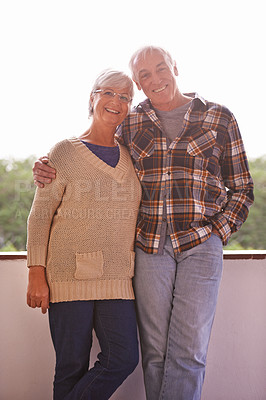 Buy stock photo Senior couple, smile and portrait on balcony with hug, love and outdoor with connection for retirement. Elderly woman, old man and embrace on patio with pride, care and happy at apartment in Germany