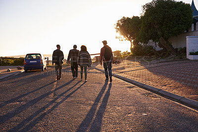 Buy stock photo Rearview shot of a group of friends walking at sunset