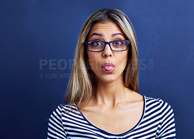 Buy stock photo Funny, face and woman with glasses in studio for tongue out, silly or humor on blue background. Need, portrait and female model with emoji expression, gesture or geek, aesthetic or quirky personality