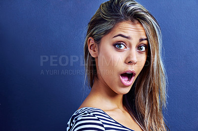 Buy stock photo Portrait of a shocked young woman isolated on blue