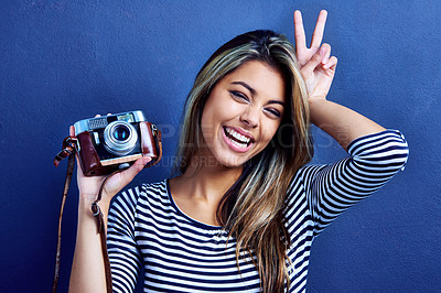 Buy stock photo Cropped shot of a playful young woman holding a camera