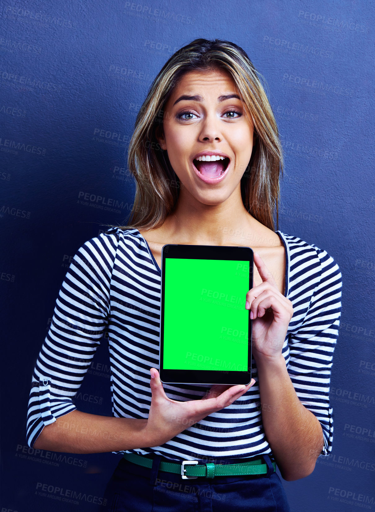 Buy stock photo Shot of an excited young woman holding a digital tablet