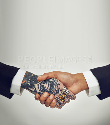 Buy stock photo Two businesspeople shaking hands, one with tattoos