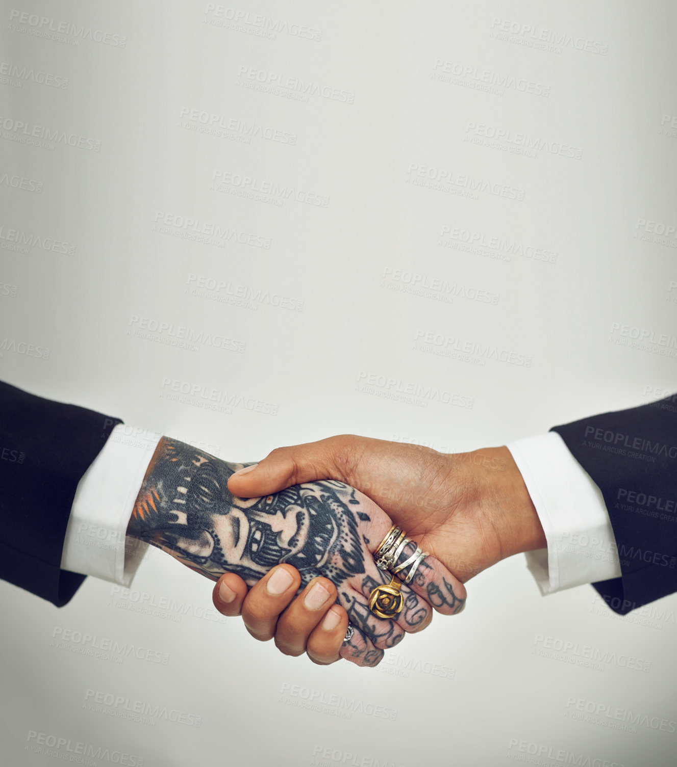 Buy stock photo Two businesspeople shaking hands, one with tattoos