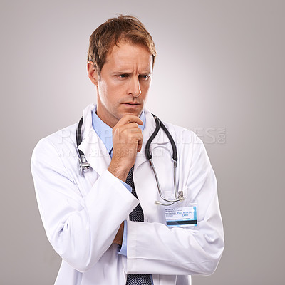 Buy stock photo Studio shot of a handsome doctor looking thoughtful