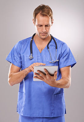 Buy stock photo Studio shot of a handsome male doctor using a digital tablet