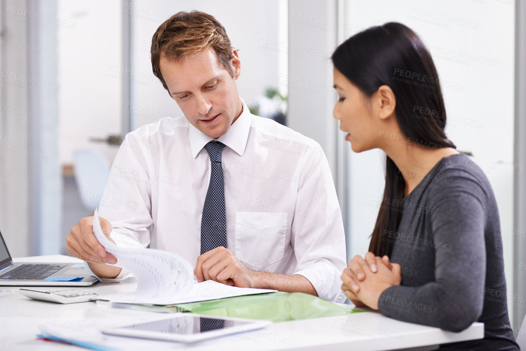 Buy stock photo Shot of two colleagues discussing work in the office