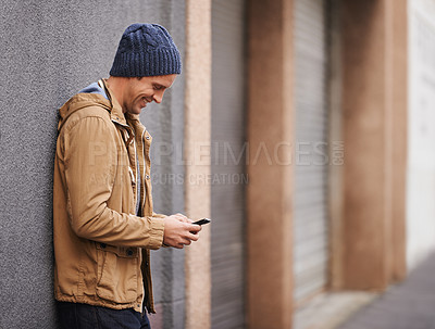 Buy stock photo Cropped shot of a fashionable man using his mobile phone in the city