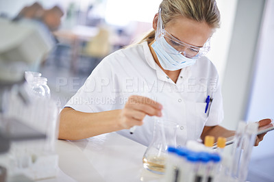 Buy stock photo A young scientist conducting an experiment in her lab