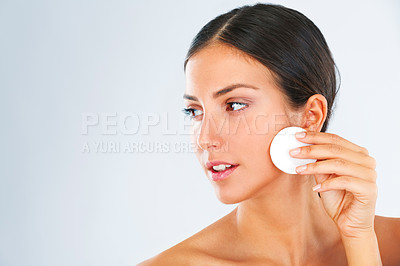 Buy stock photo A beautiful young woman wiping her cheeks with a cotton swab