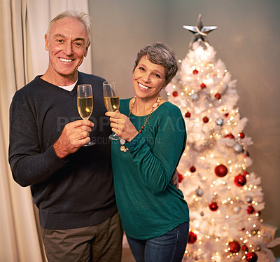 Buy stock photo Christmas, portrait and champagne of senior couple with love, care and support in a home on holiday. Tree, retirement and marriage with a smile and hug in a house with celebration drink and cheers