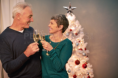 Buy stock photo Cropped shot of a happy mature couple toasting each other on Christmas eve