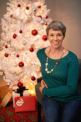 Buy stock photo Christmas, tree and portrait of mature woman in home for holiday with presents on vacation. Happy, person and relax on with festive xmas decoration and gift box in living room and enjoy retirement