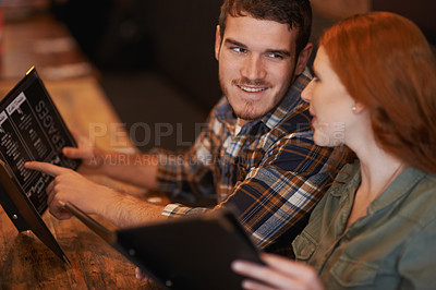 Buy stock photo Happy couple, restaurant and reading with menu for option, choice or decision on romantic dinner date. Man and woman with smile for meal, selection or pick on price list at indoor coffee shop or cafe