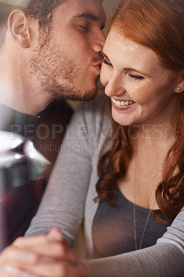 Buy stock photo Happy couple, kiss and love with embrace for support, intimacy or affection together at indoor cafe. Man and woman with affection on cheek for date, relationship or romantic bonding at coffee shop