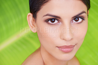 Buy stock photo Studio portrait of a beautiful young woman posing in front of a leaf