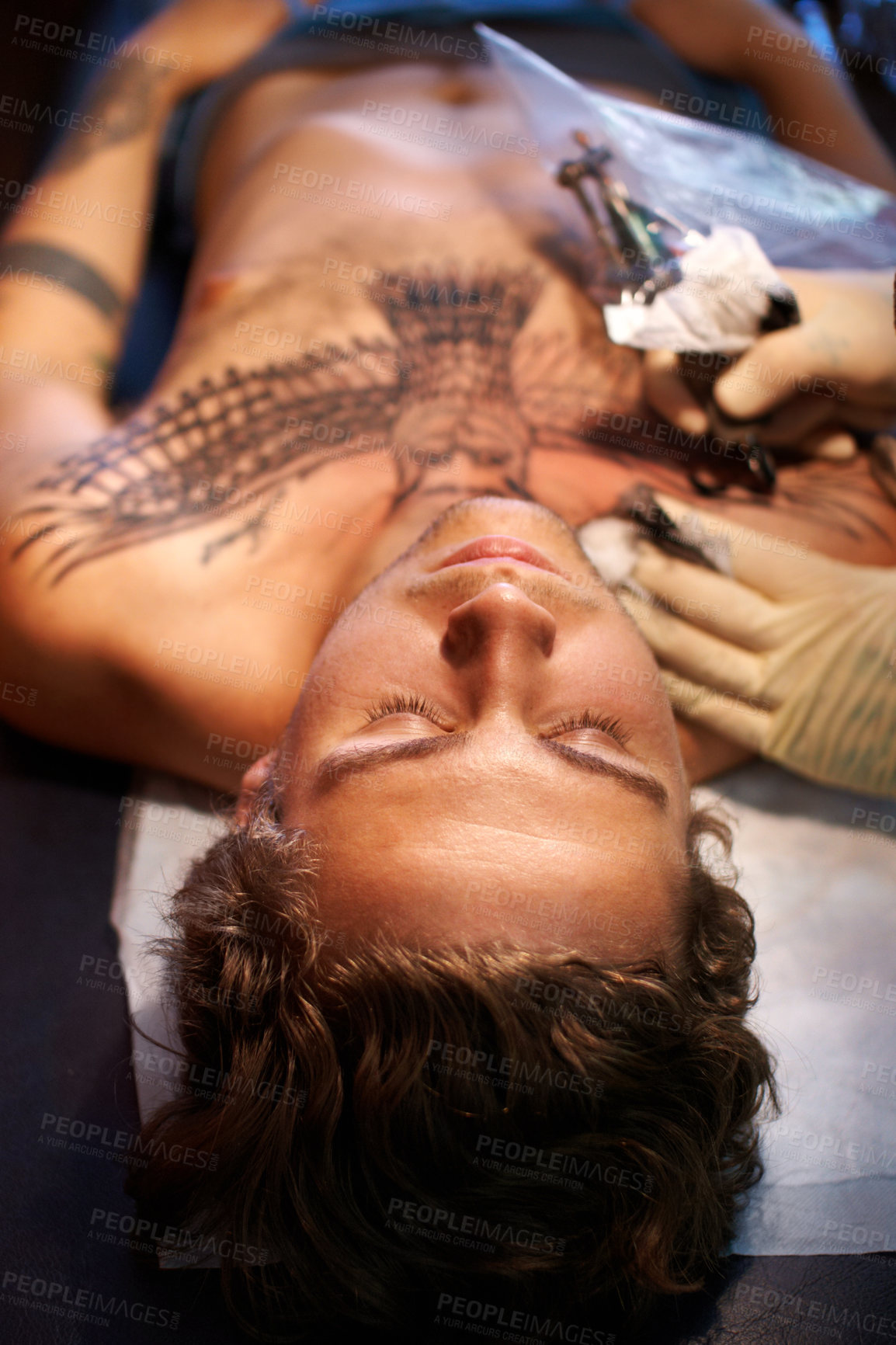 Buy stock photo Creative, art and tattoo with man on table and machine in store for ink graphic, culture and drawing. Design, punk and identity with hand of artist and person in salon for picture, painting and body