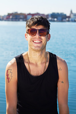 Buy stock photo A fashionable young man with tattoos dressed in punk apparel, relaxing outdoors