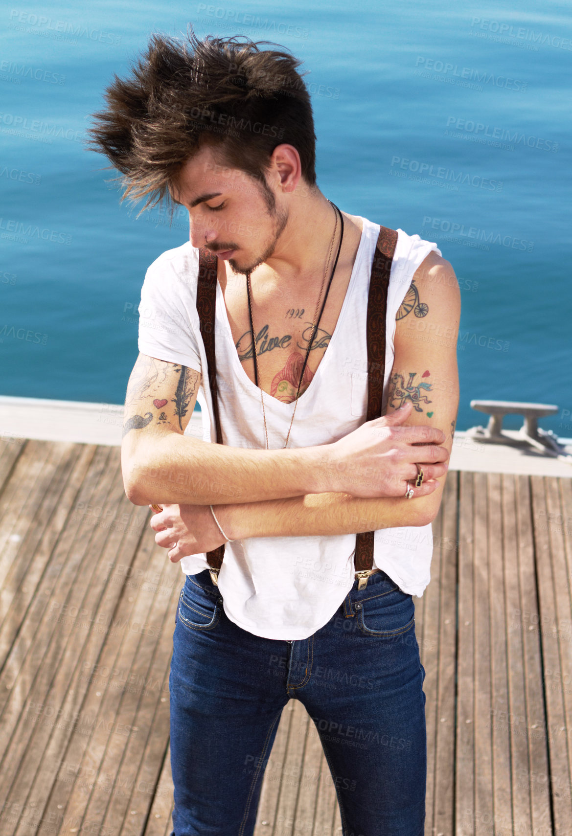 Buy stock photo Punk dress code, man with tattoos and on pier outdoors at the beach. Health wellness, travel or journey and male fashion model with tattoo ink on his body outside of the sea for nature fresh air 