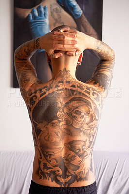 Buy stock photo Rearview shot of a young man with tattoos on his back
