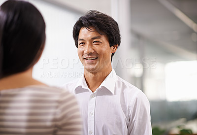 Buy stock photo Happy, cooperation and businessman in conversation at office with feedback on project collaboration. Japanese, employee and talking to woman with discussion of ideas, development or social teamwork