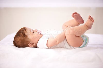 Buy stock photo Relax, baby and playing on bed for care, calm kid and diaper comfort in nursery with pacifier. Child development, girl infant in family home for nap time, wellness growth and resting in bedroom