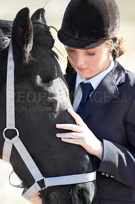 Buy stock photo Shot of a beautiful young woman standing next to her horse