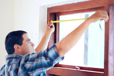 Buy stock photo Shot of a middle aged handy man measuring a window