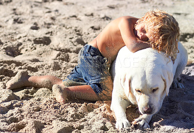 Buy stock photo Shot of a boy playing with his dog at the beach