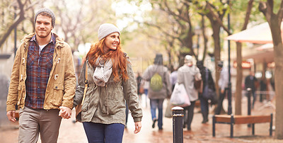 Buy stock photo Happy couple, holding hands and walking in city together in winter for romance or travel outdoors. Man and woman having a walk or stroll in park or town in happiness for romantic trip or traveling