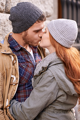 Buy stock photo Couple, love and kiss with closeup in outdoor in against wall on cold weather, together and support in London. Affection, relationship and bonding for romance with soulmate, care and happiness 