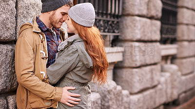 Buy stock photo Couple, love and kiss with smile in outdoor or against wall in cold weather, together and support in London. Relationship, affection and bonding for romance with care, happiness and kindness 