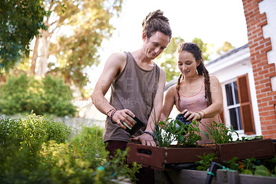 Buy stock photo Shot of a happy young couple enjoying a day of gardening