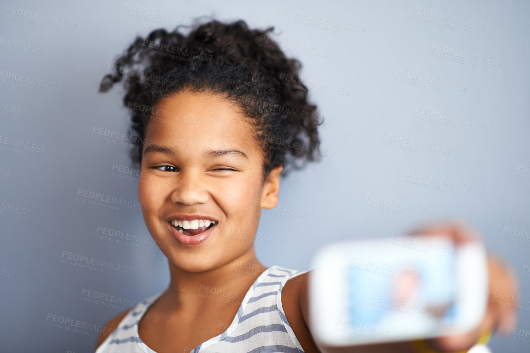 Buy stock photo Young girl, selfie and wink in studio for happiness, closeup and vibrant teen by grey background. Child, smile and excited teenager with profile picture, technology and update on social media