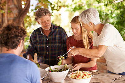 Buy stock photo A view of a family preparing to eat lunch together outdoors