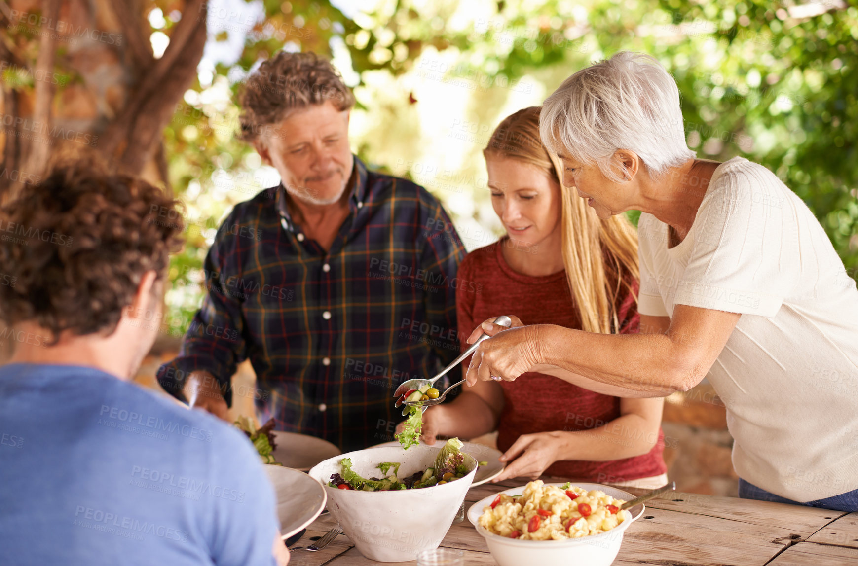 Buy stock photo A view of a family preparing to eat lunch together outdoors