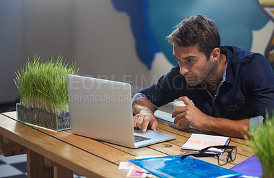 Buy stock photo A focused young entrepreneur hard at work on his laptop