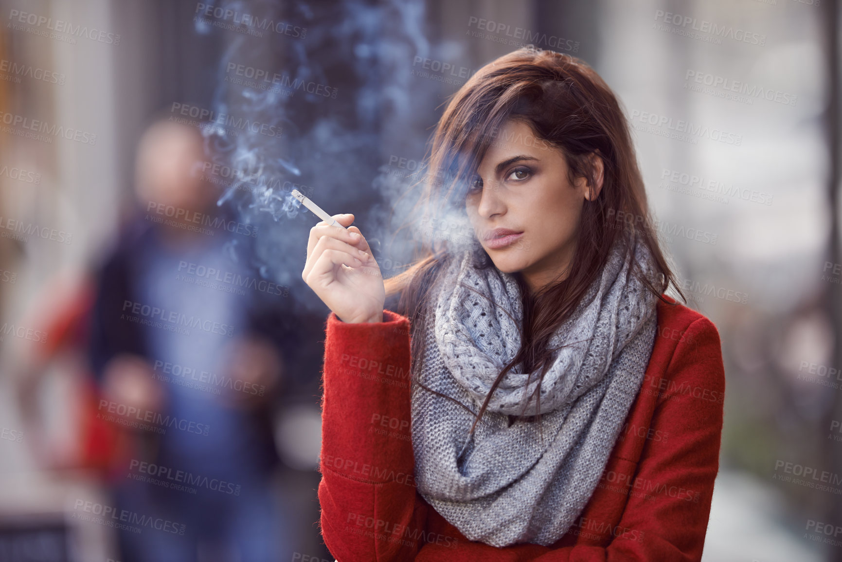 Buy stock photo Portrait of a beautiful and fashionable young woman smoking a cigarette in an urban setting