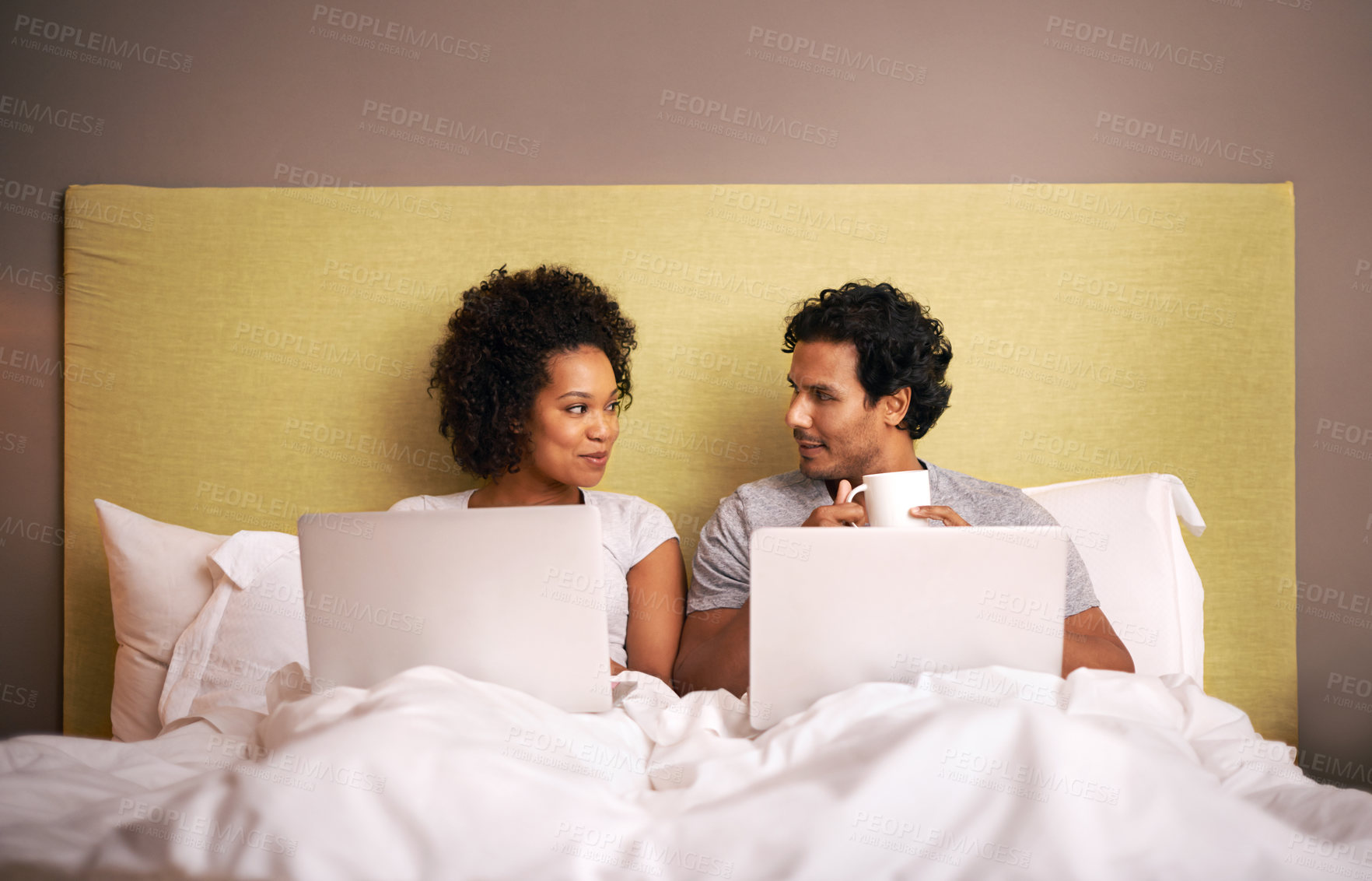 Buy stock photo Bedroom, laptop and couple with smile for working from home in apartment, love and writers for romance. Partners, woman and man on bed of house with technology for career and coffee in morning