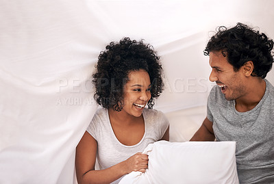 Buy stock photo Couple, bed and pillow playful with sheet for carefree weekend with partnership, happiness or bonding. Man, woman and linen in apartment for holiday vacation on morning comfort, peace or relaxing