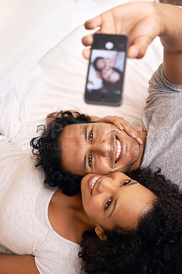 Buy stock photo A cute couple taking a selfie on the bed