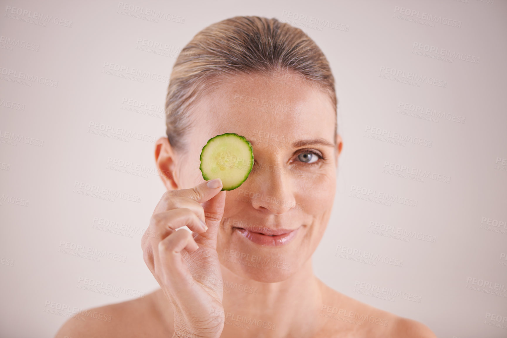 Buy stock photo Beauty, cucumber and portrait of mature woman in studio for health, wellness or natural routine. Smile, skincare and female person with organic vegetable for dermatology treatment by white background