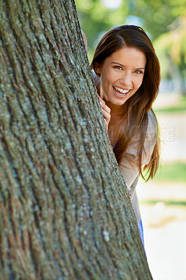 Buy stock photo Woman, park and tree with hide, smile and portrait with happiness and green fun for nature. Lady, laugh and sun with grass, forest and happy for excited playful summer with optimism and sunshine