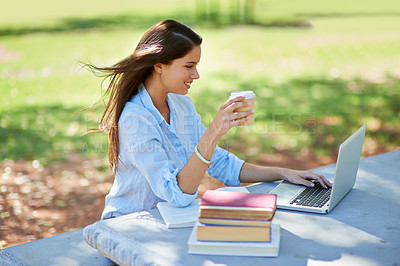 Buy stock photo Shot of a beautiful young college student sitting with her laptop and books at the park