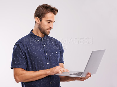 Buy stock photo A studio shot of a handsome man using a laptop