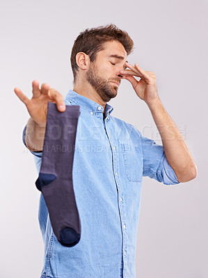 Buy stock photo Man, smelly socks and closing nose for poor hygiene with clothes, bad odor or stink with disgust isolated on white background. Unpleasant, dirty and foul with negative reaction for stench in studio
