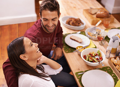 Buy stock photo A happy couple enjoying a family meal around the table