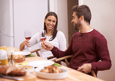 Buy stock photo Cheers, dinner and smile with couple at table in dining room, food, and drinks for celebration in home. Toast, man and woman at lunch together with wine, fun and happiness, relax and holiday date